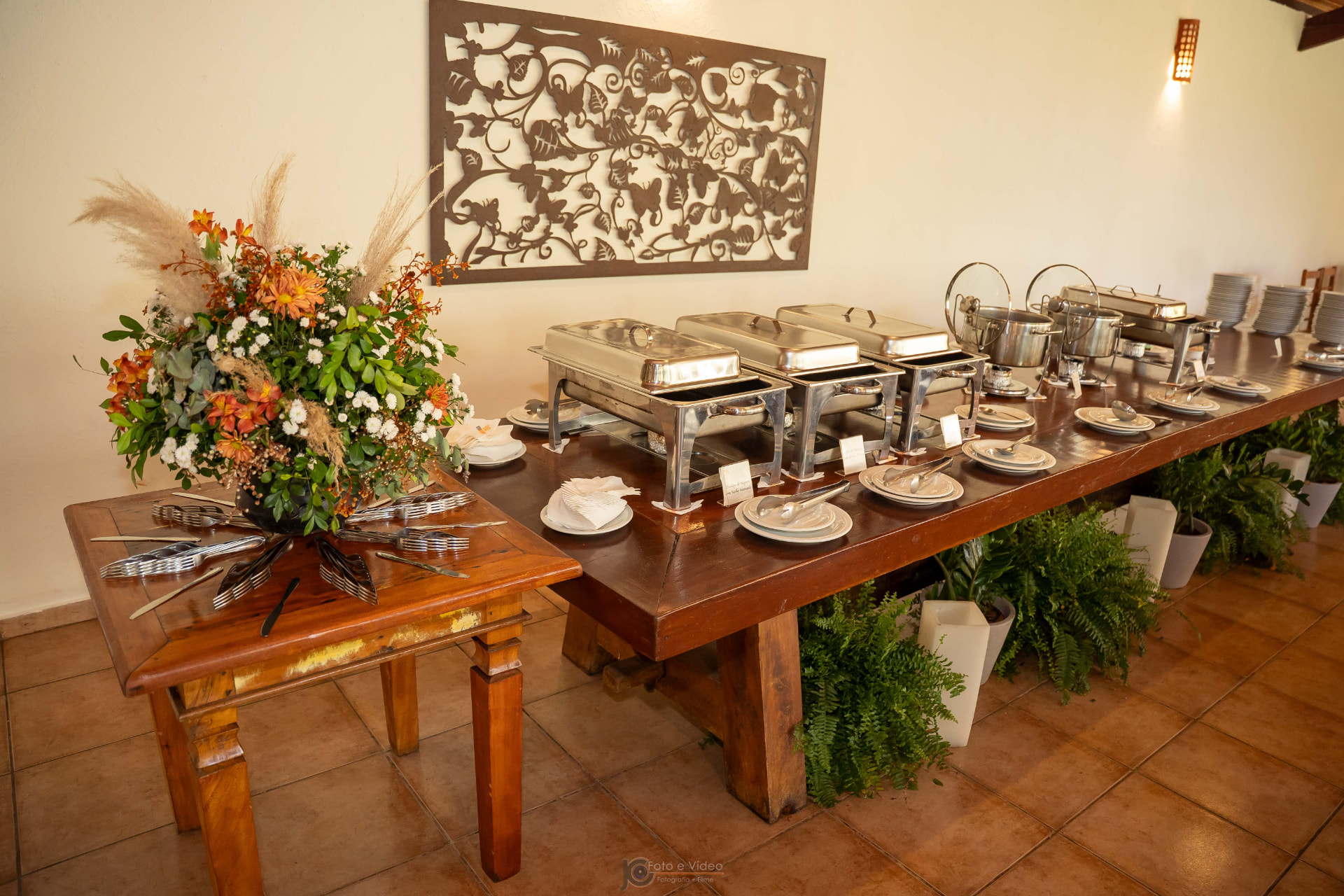 Mesa de buffet decorada com arranjos e prataria