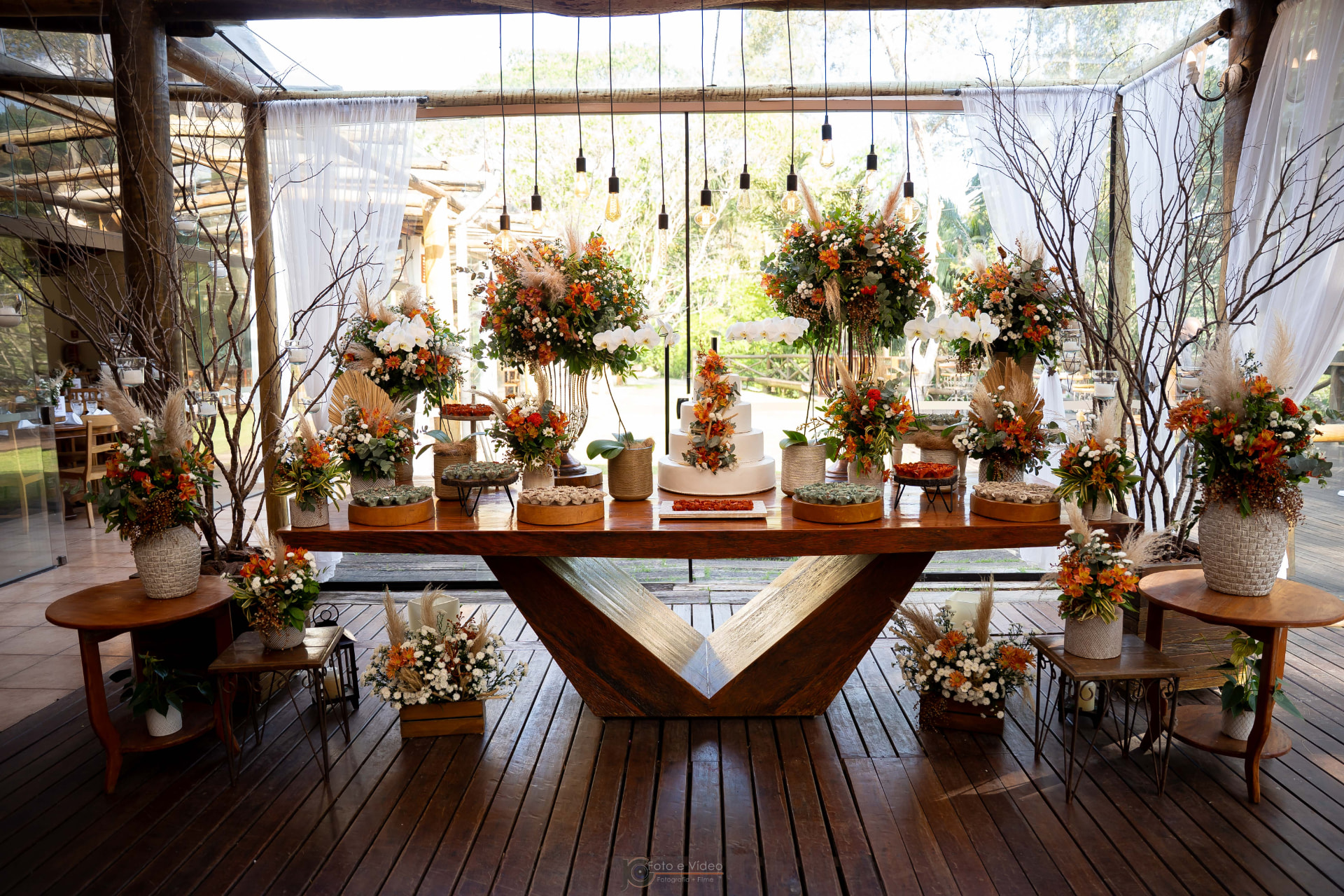 Mesa de doces rústica com lâmpadas suspensas