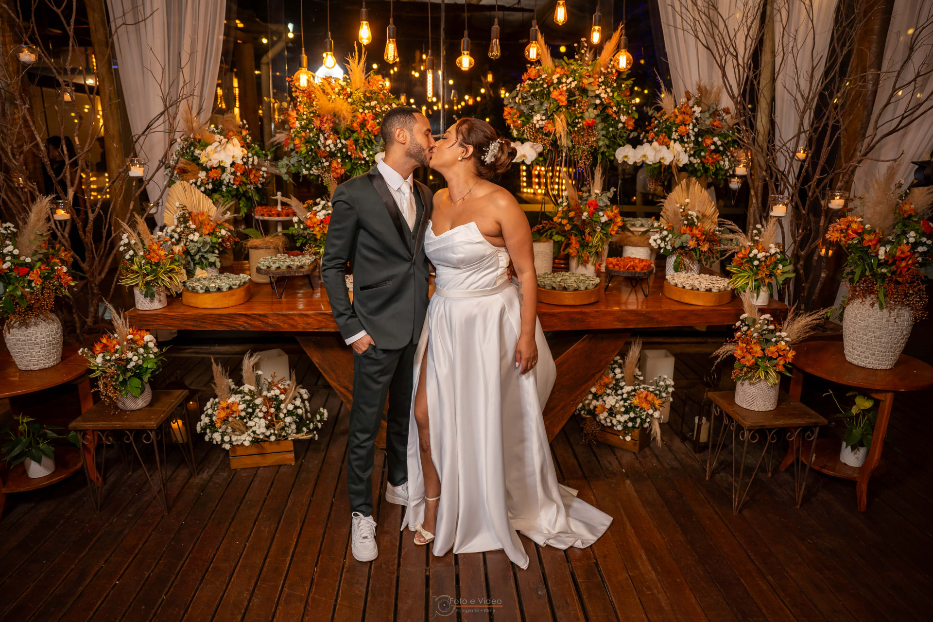 Casal em frente à mesa de doces com luzes